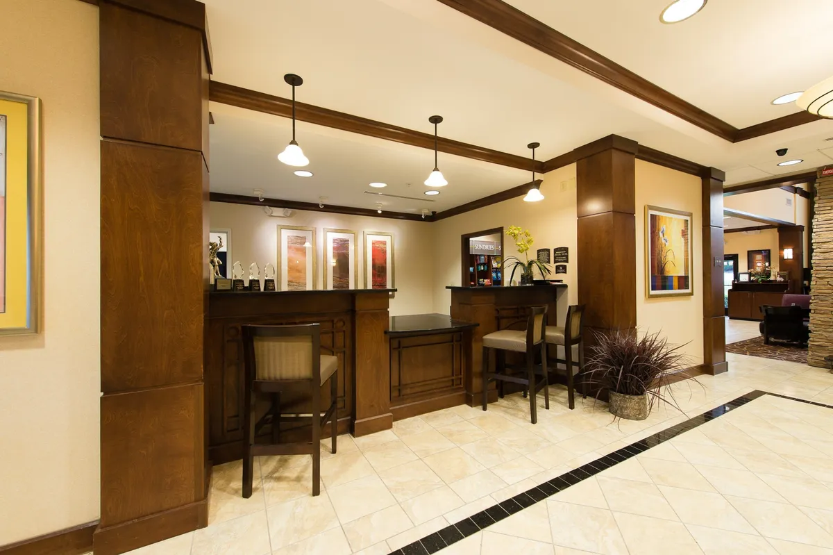 This image captures the hotel’s reception area, featuring a professional front desk, welcoming seating area, and local artwork on the walls. Guests are seen checking in and interacting with staff, setting a tone of efficient service and hospitality.